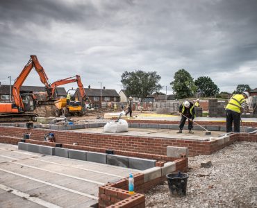 Workers laying bricks on construction site